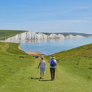 2 men standing on green grass field near body of water during daytime